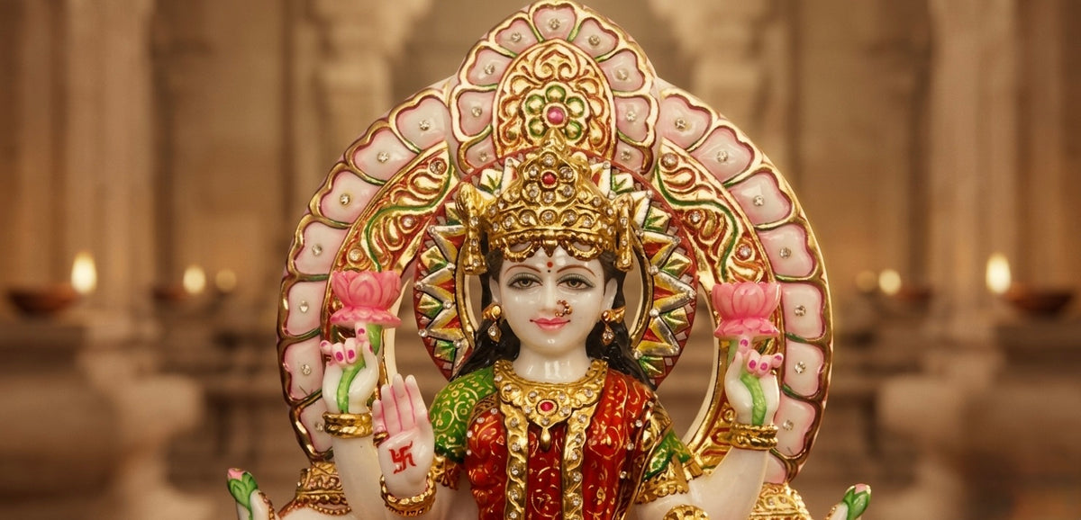 Goddess Laxmi statue with a round halo at the back in dark red sari and beautiful embose gold leaf work